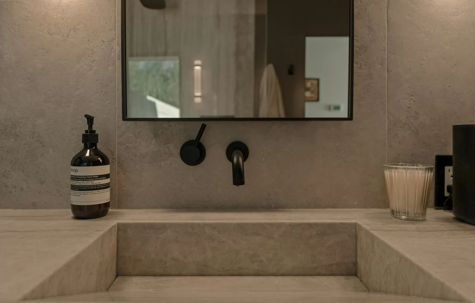 Integrated stone basin with a matte black wall faucet